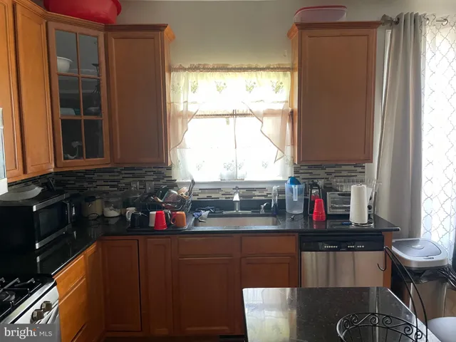 a kitchen with stainless steel appliances granite countertop a stove and a refrigerator
