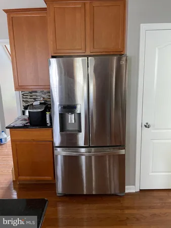 a kitchen with stainless steel appliances granite countertop a refrigerator and a cabinets