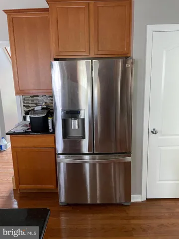 a kitchen with stainless steel appliances granite countertop a refrigerator and a cabinets