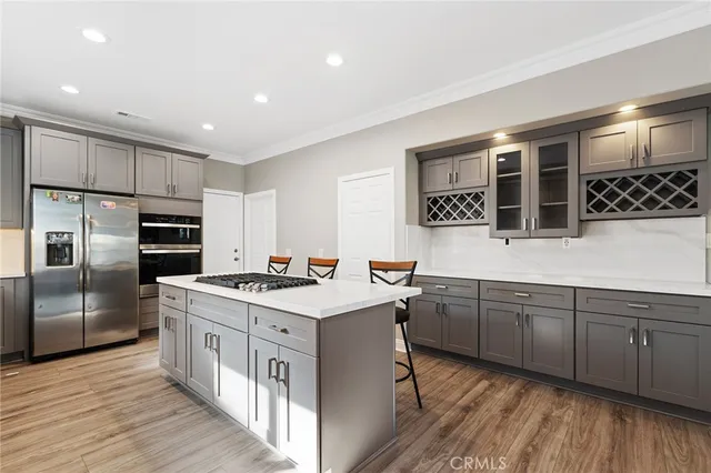 a kitchen with a sink a stove a refrigerator cabinets and dining table