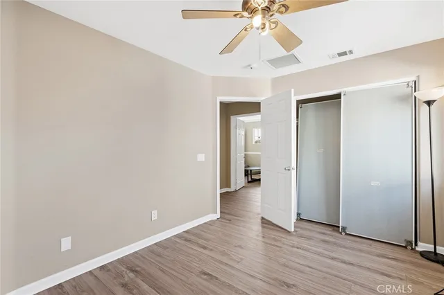 a spacious bedroom with a bed and wooden floor