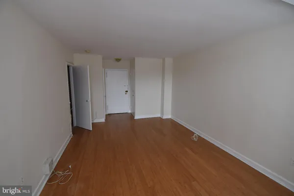 a view of empty room with wooden floor