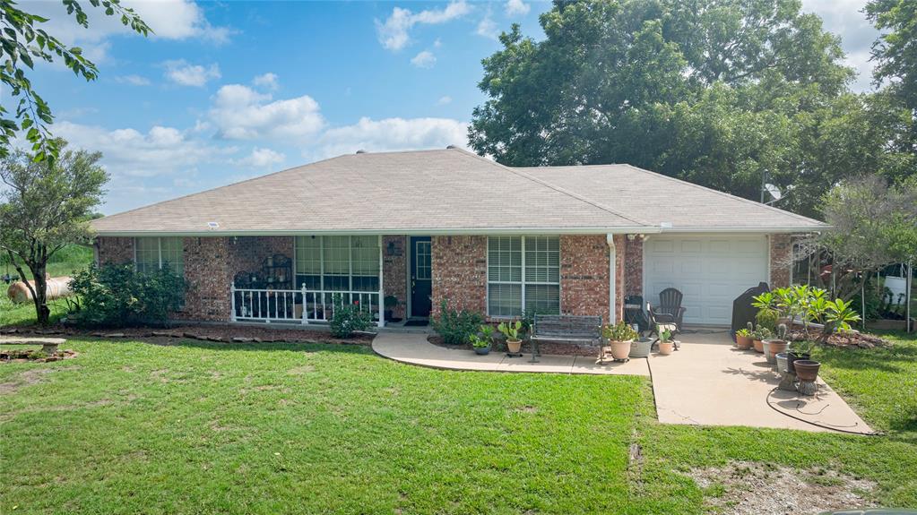 12097 Kyle Lane Blue Ridge, TX 75424 - Photo 10 of 13 a front view of a house with garden and porch