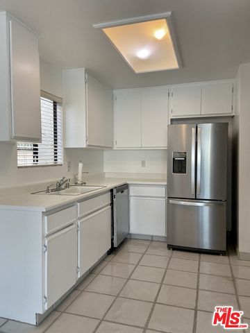 a kitchen with a refrigerator sink and cabinets