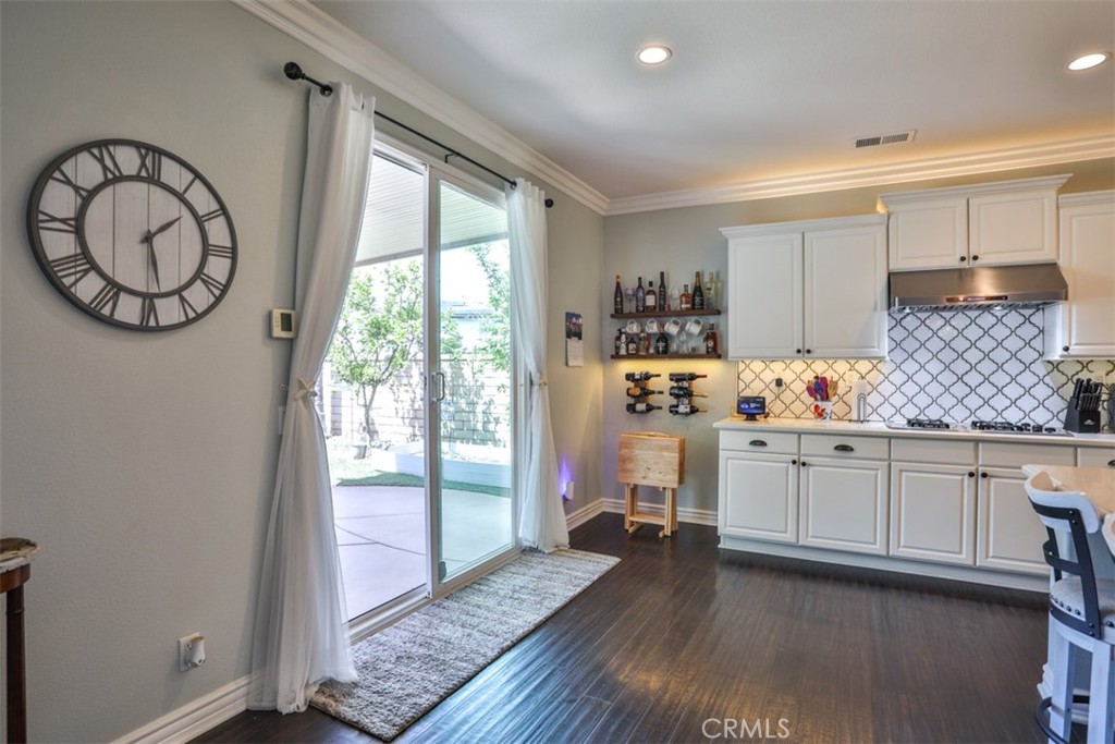 3250 Quartz Circle Corona, CA 92882 - Photo 21 of 68 a kitchen with granite countertop a stove a sink and white cabinets with wooden floor next to windows