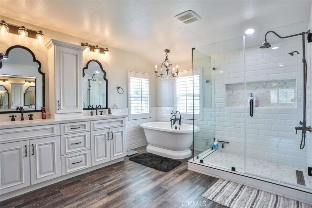 3250 Quartz Circle Corona, CA 92882 - Photo 35 of 68 a spacious bathroom with a double vanity sink a mirror a bathtub and next to a window