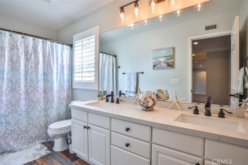 3250 Quartz Circle Corona, CA 92882 - Photo 46 of 68 a bathroom with a double vanity sink toilet and a mirror