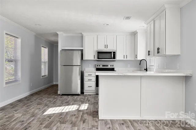 a kitchen with a refrigerator sink and white cabinets