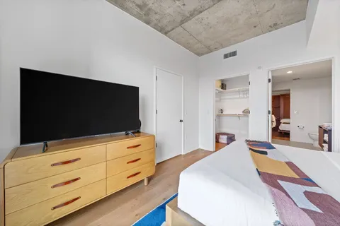 a bedroom with a bed and a flat screen tv