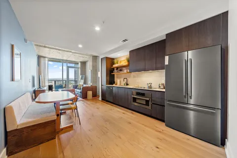 a kitchen with stainless steel appliances wooden floor and large window
