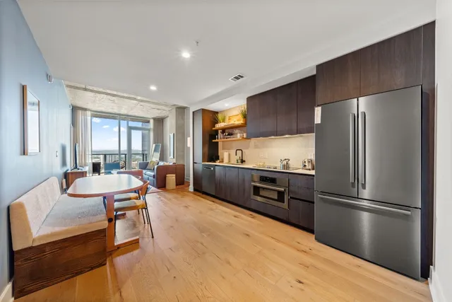 a kitchen with stainless steel appliances wooden floor and large window
