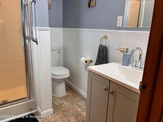 a bathroom with a sink a toilet and a mirror