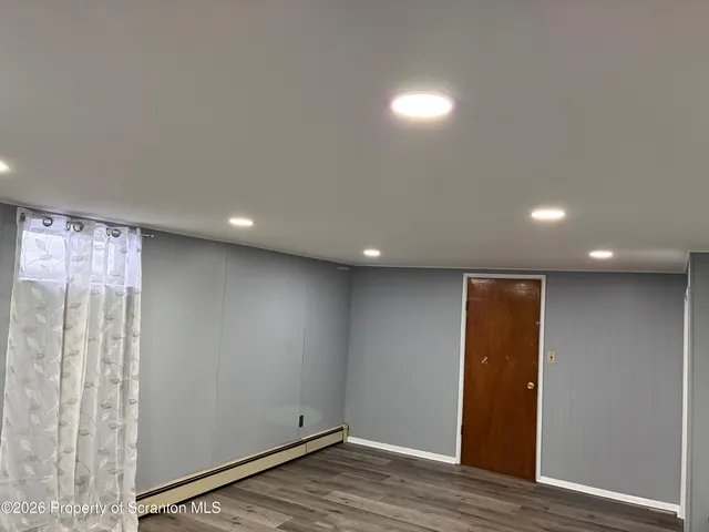 a view of an empty room with wooden floor