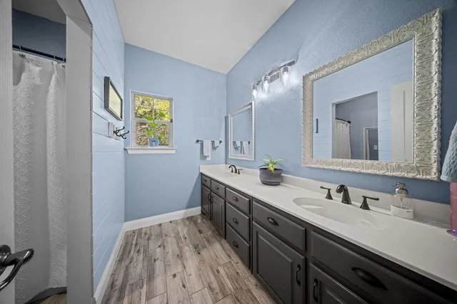 a spacious bathroom with a double vanity sink and a mirror