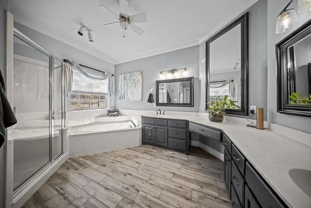 a large bathroom with a large tub sink vanity granite and a large mirror
