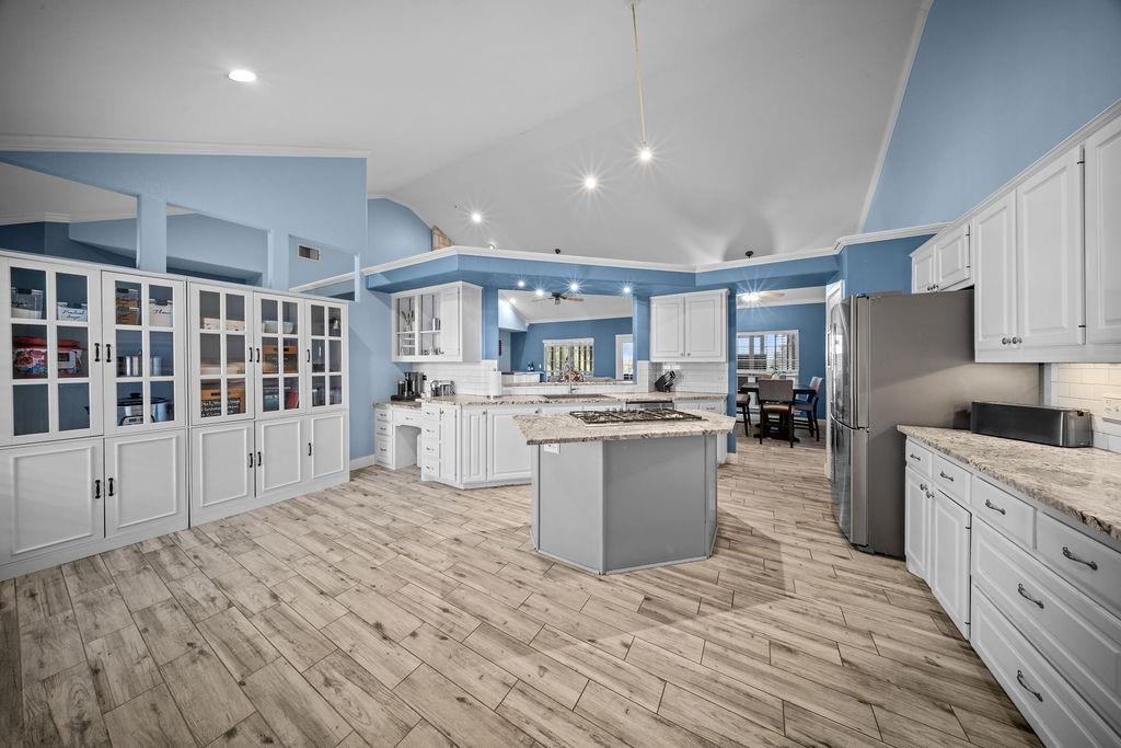 831 Union Hill Road Ennis, TX 75119 - Photo 6 of 36 a large white kitchen with kitchen island a sink a center island and stainless steel appliances