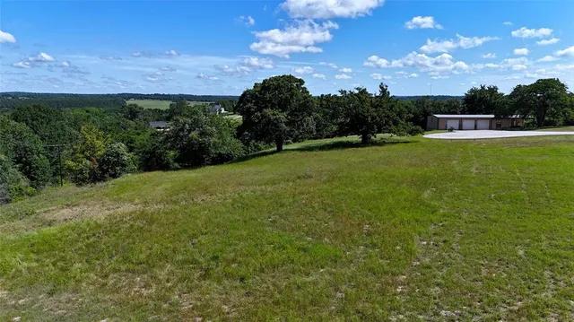 a view of a big yard with a house in the background