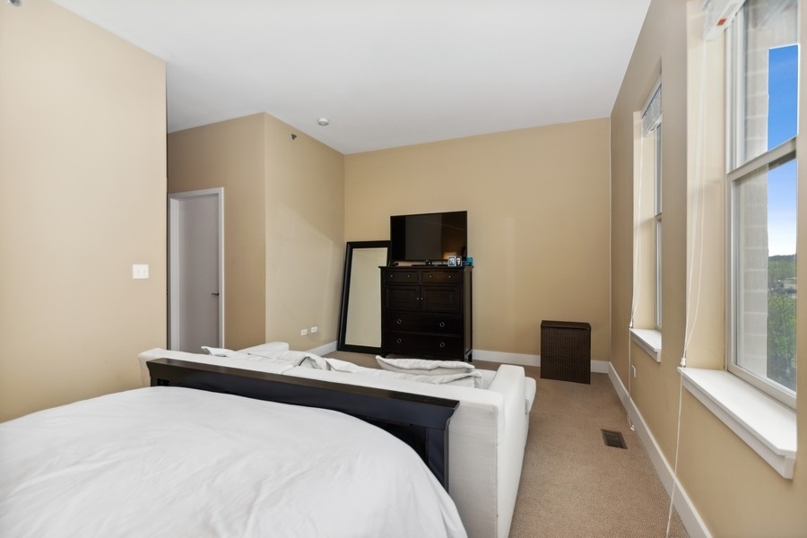 339 Front Street, Unit 2207 Lemont, IL 60439 - Photo 13 of 27 a bedroom with a bed and a flat tv screen next to a window