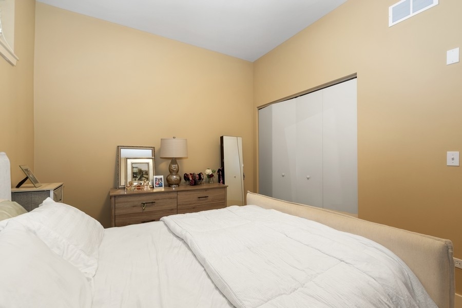 339 Front Street, Unit 2207 Lemont, IL 60439 - Photo 17 of 27 a bedroom with a bed and a large mirror
