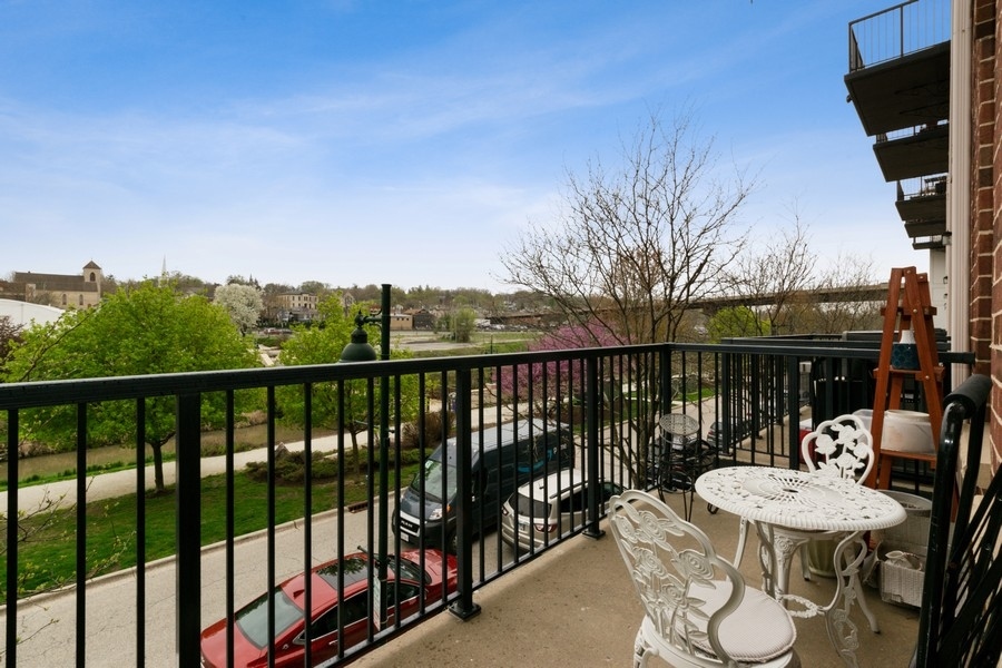 339 Front Street, Unit 2207 Lemont, IL 60439 - Photo 23 of 27 a view of a balcony with chairs and a table