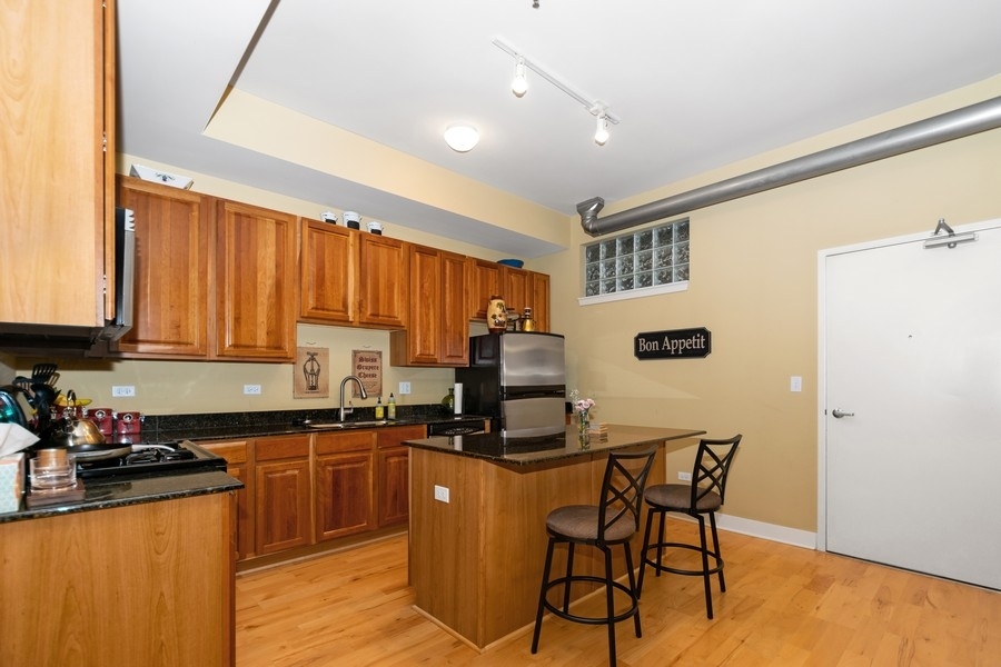 339 Front Street, Unit 2207 Lemont, IL 60439 - Photo 4 of 27 a kitchen with granite countertop a sink cabinets and stainless steel appliances