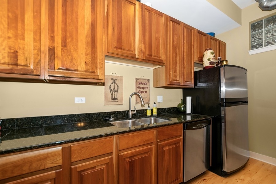 339 Front Street, Unit 2207 Lemont, IL 60439 - Photo 7 of 27 a kitchen with granite countertop stainless steel appliances a refrigerator and a sink