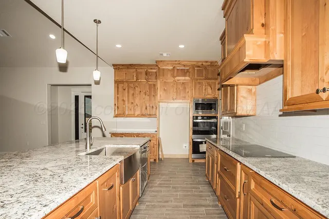 a kitchen with stainless steel appliances granite countertop a sink and a refrigerator