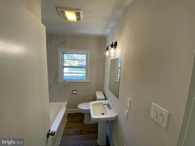 a bathroom with a sink a toilet and mirror