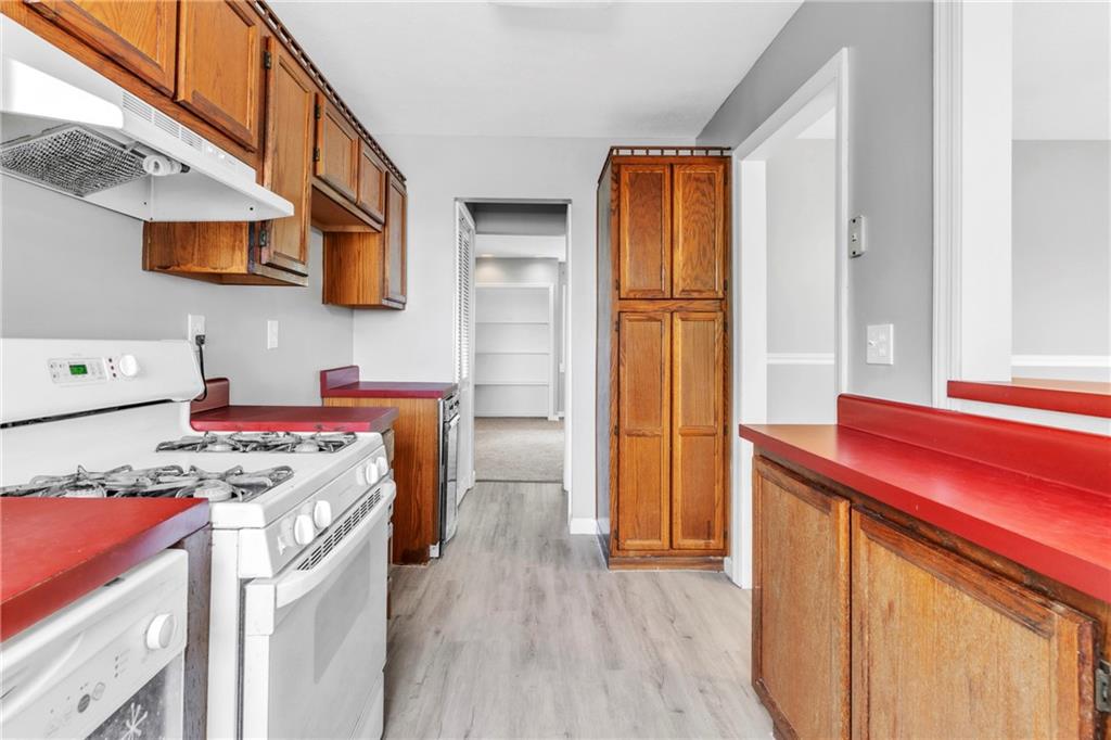 530 Griffin Street Pittsburgh, PA 15211 - Photo 13 of 41 a kitchen with stainless steel appliances granite countertop a refrigerator a stove and a wooden floor