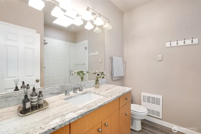 a bathroom with a granite countertop sink a toilet and a mirror