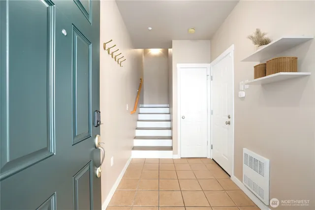 a view of a hallway with entryway and stairs
