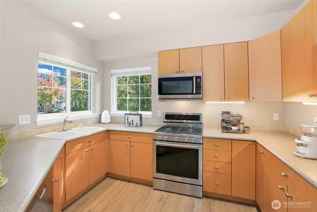 a kitchen with a sink stove top oven and cabinets
