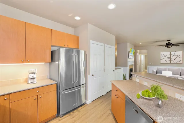a kitchen with stainless steel appliances granite countertop a sink a refrigerator and a stove top oven