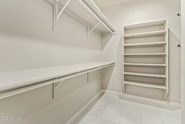 a view of walk in closet with empty racks