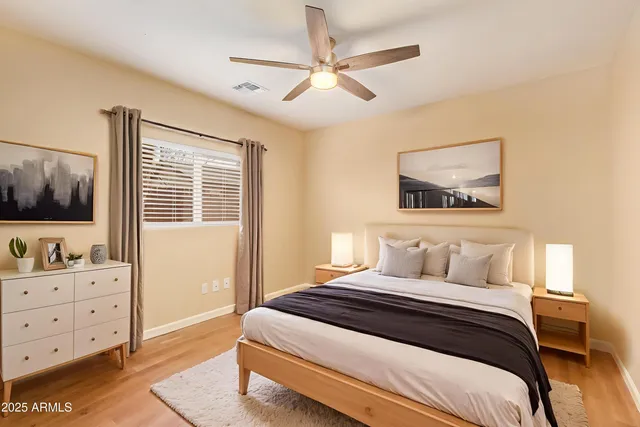 a bedroom with a bed and a flat tv screen on dresser