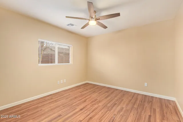 a view of a room with wooden floor and a ceiling fan