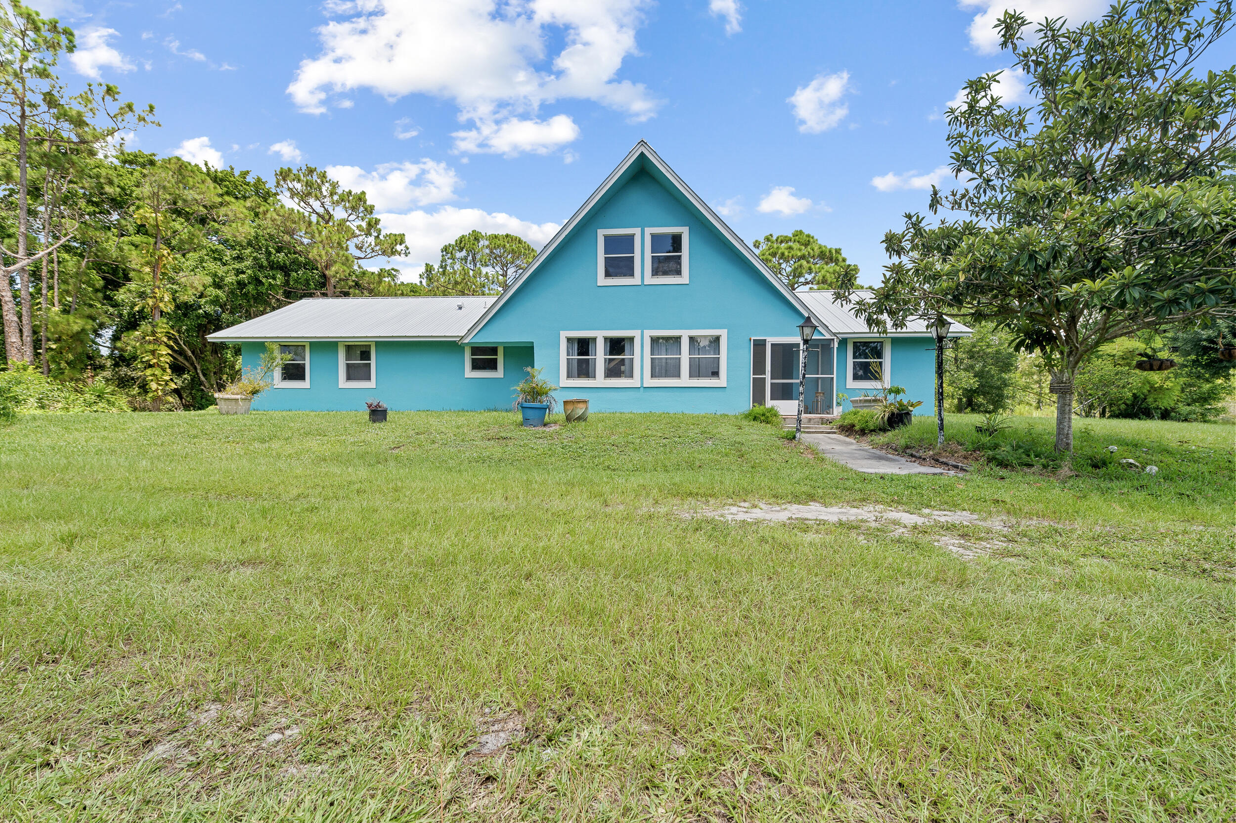 12450 77th Street Fellsmere, FL 32948 - Photo 6 of 44 a view of a house with a big yard and large trees
