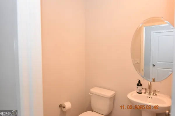a bathroom with a toilet a sink and mirror