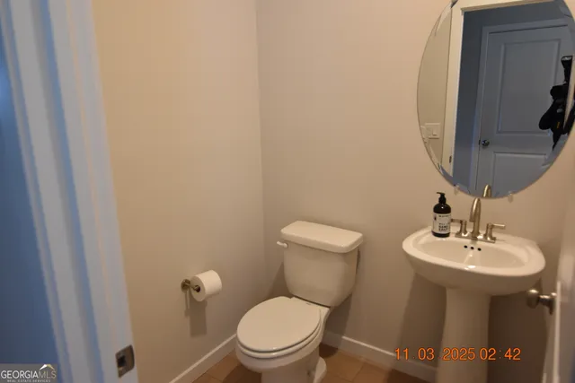 a bathroom with a toilet a sink and mirror