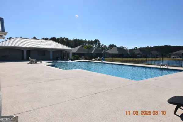 a view of a swimming pool with a patio and a yard