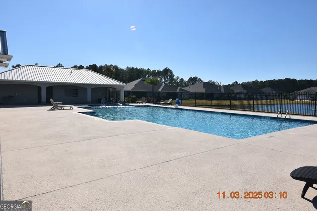 a view of a swimming pool with a patio and a yard