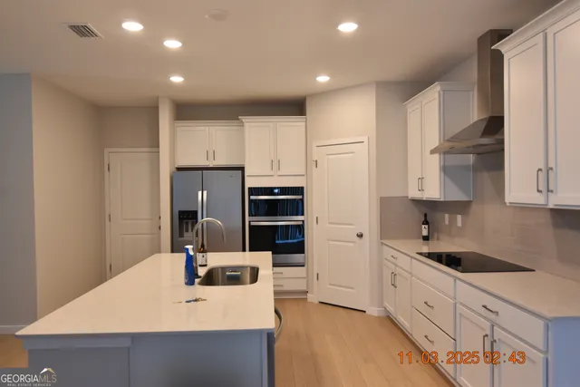 a kitchen with stainless steel appliances a sink stove and refrigerator