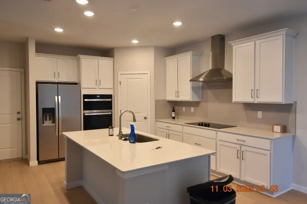 a kitchen with stainless steel appliances a sink a stove a refrigerator and cabinets
