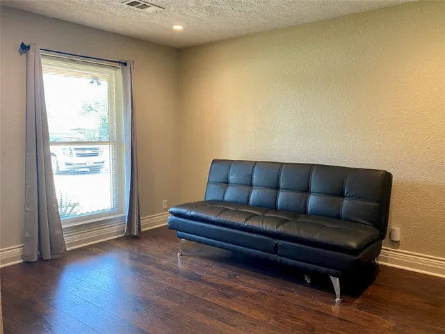 a living room with a couch and wooden floor
