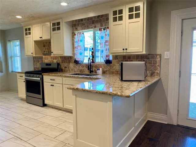 a kitchen with stainless steel appliances granite countertop a sink stove and cabinets