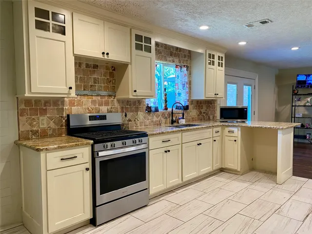 a kitchen with a stove top oven sink and cabinets