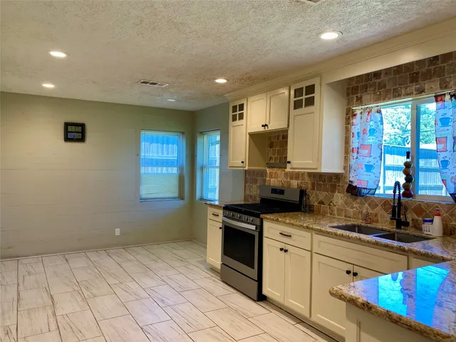 a kitchen with a sink window and cabinets
