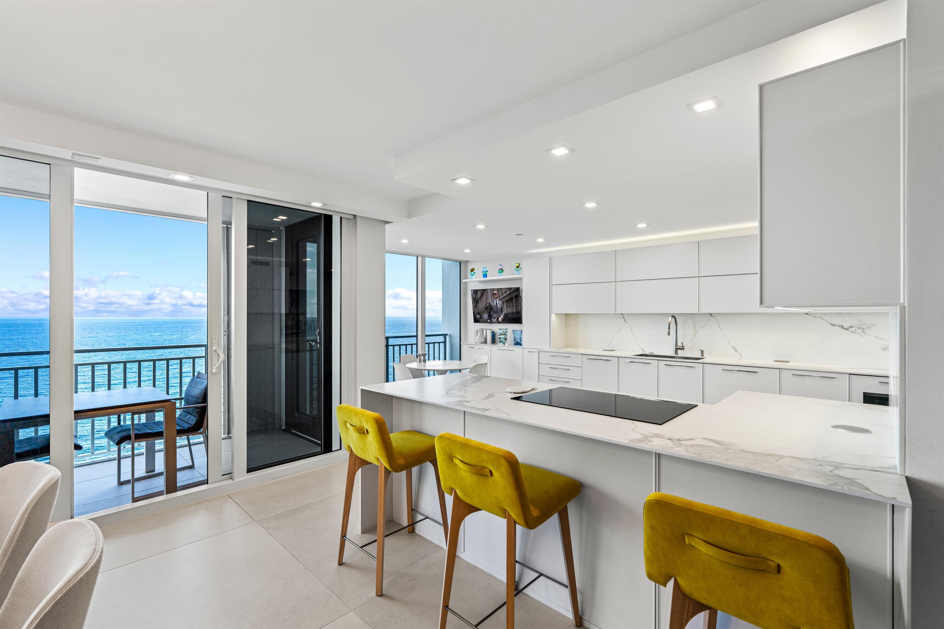 2600 South Ocean Boulevard, Unit 19E Boca Raton, FL 33432 - Photo 13 of 53 a kitchen with a sink a table and chairs in it