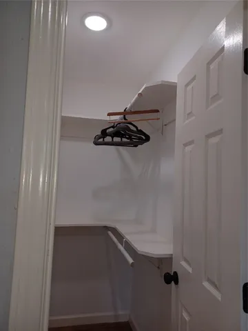 a bedroom with a bed a mirror and a window