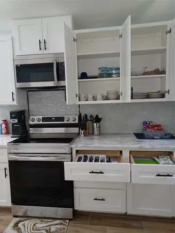 a kitchen with stainless steel appliances granite countertop a stove and a microwave